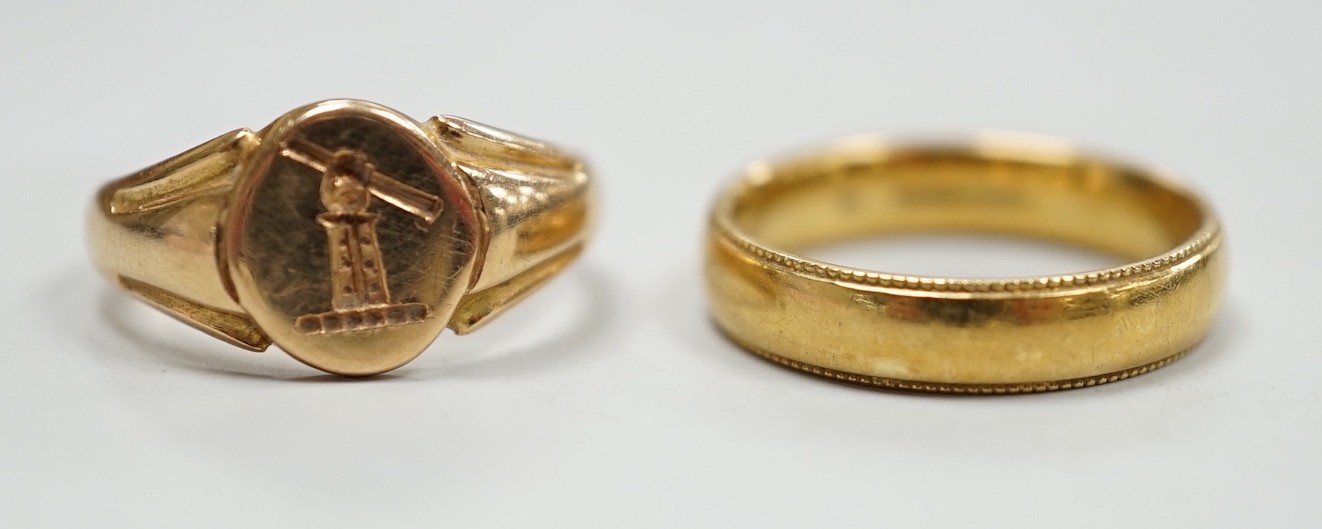 An early 20th century small 18ct gold signet ring, engraved with armorial, size G/H and a modern 18ct gold band, size I, with engraved inscription, 7.6 grams.